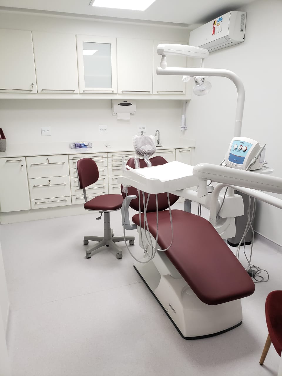Consultório Dental I – cadeira dental vermelha e bancada equipada